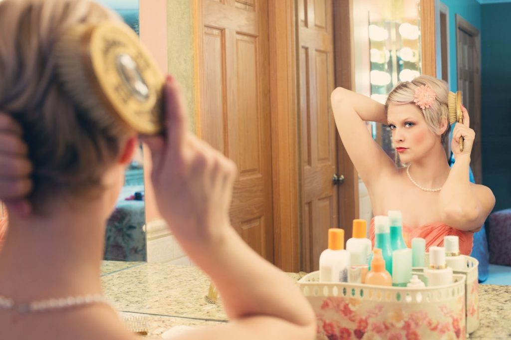 Woman with radiant natural skin looking in mirror